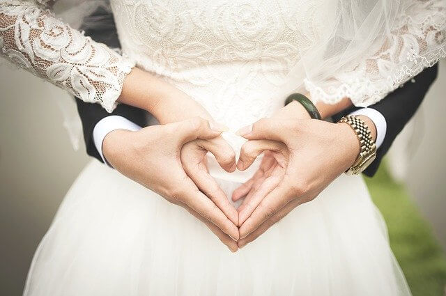 Les mariés montrent un cœur avec leurs mains