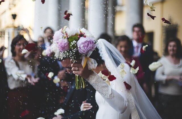 Bridal couple holding a bouquet together after the wedding