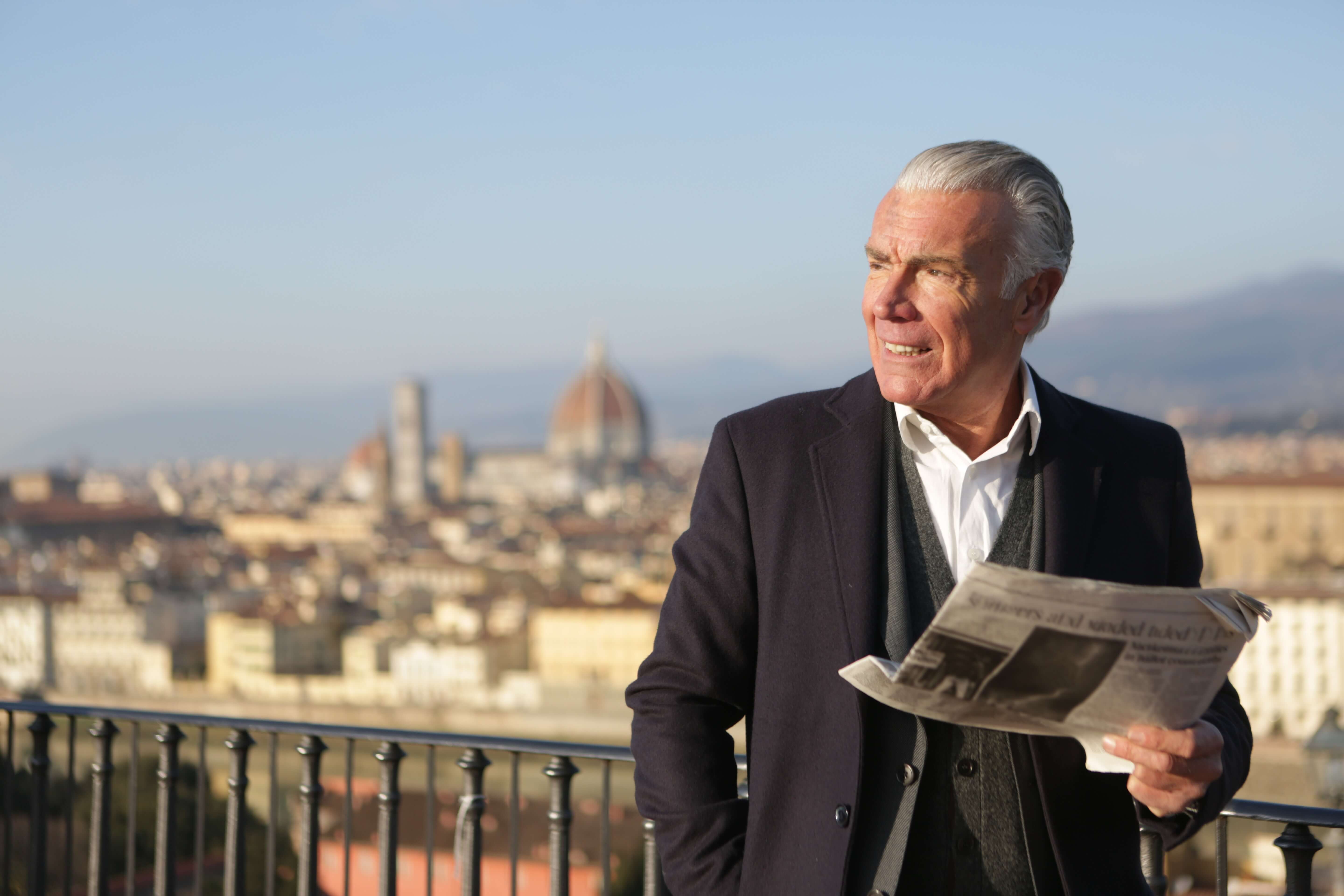 Grandpa reads a newspaper and smiles