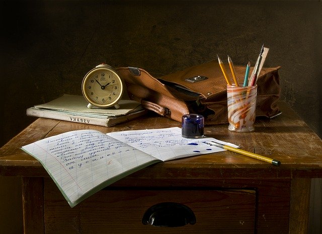 Bureau avec cahier et nombreux crayons